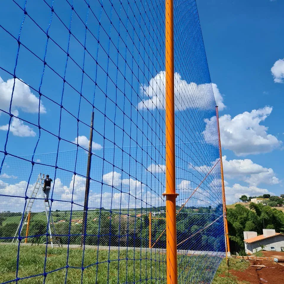 Rede de proteção esportiva azul instalada em campo